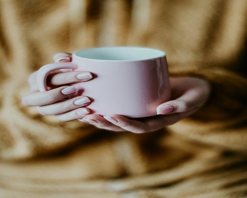 Relaxed hands holding tea cup morning
